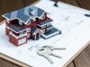 Villa house model, key and drawing on retro desktop (real estate sale concept)